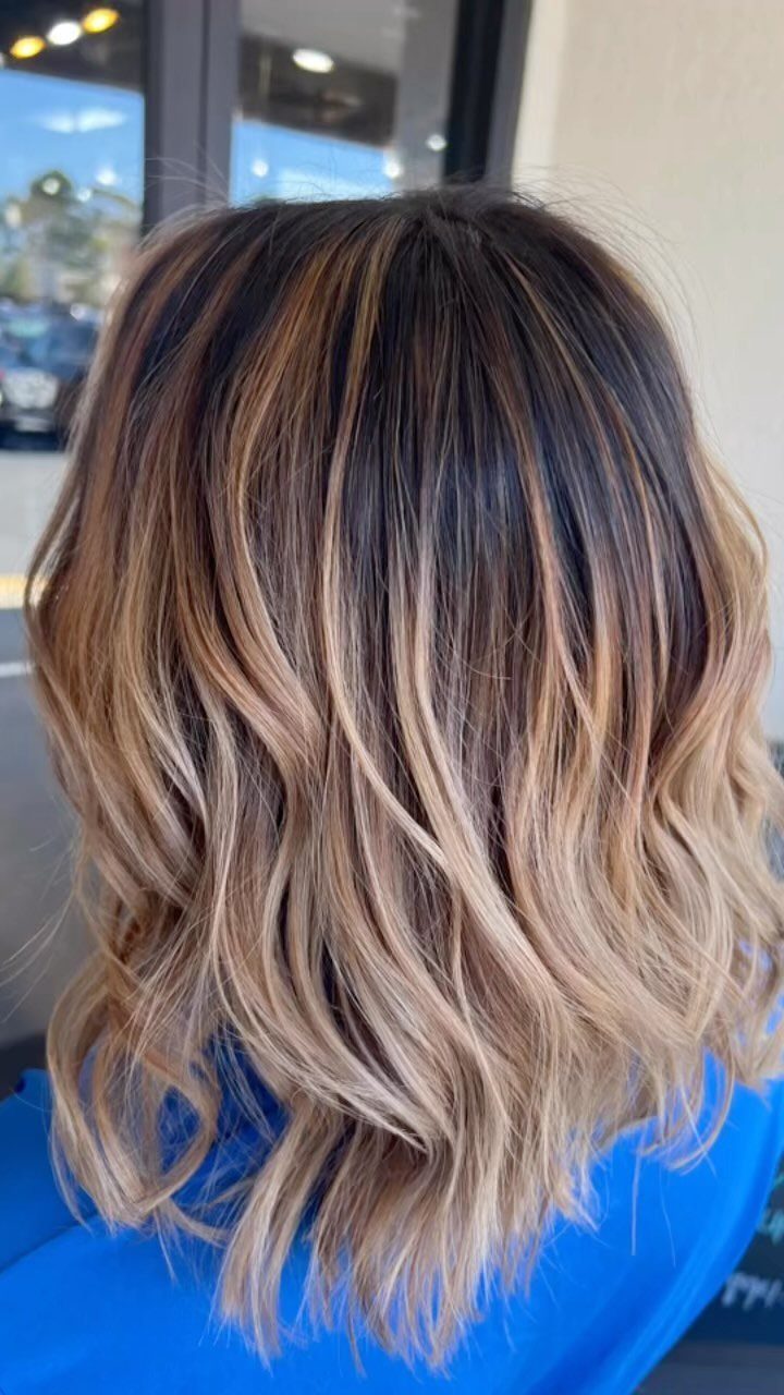 Wavy brown hair with blended caramel and blonde highlights