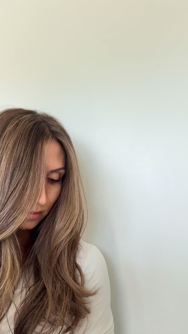 Long brown hair with fine sun-kissed highlights and soft waves