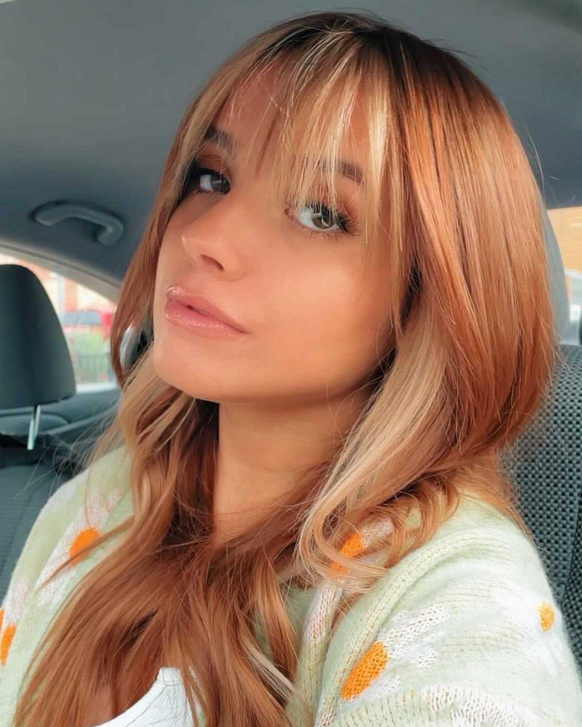 Woman with copper strawberry-blonde hair and blonde face-framing highlights