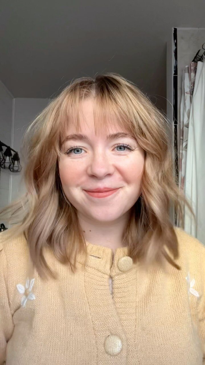 Woman with a natural strawberry blonde shoulder-length lob and soft bangs
