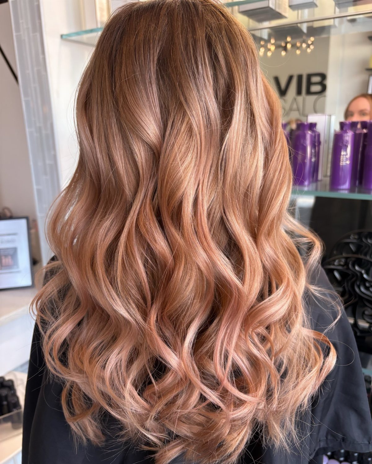 Long curled hair blends rosy pink, golden blonde, and warm brown tones