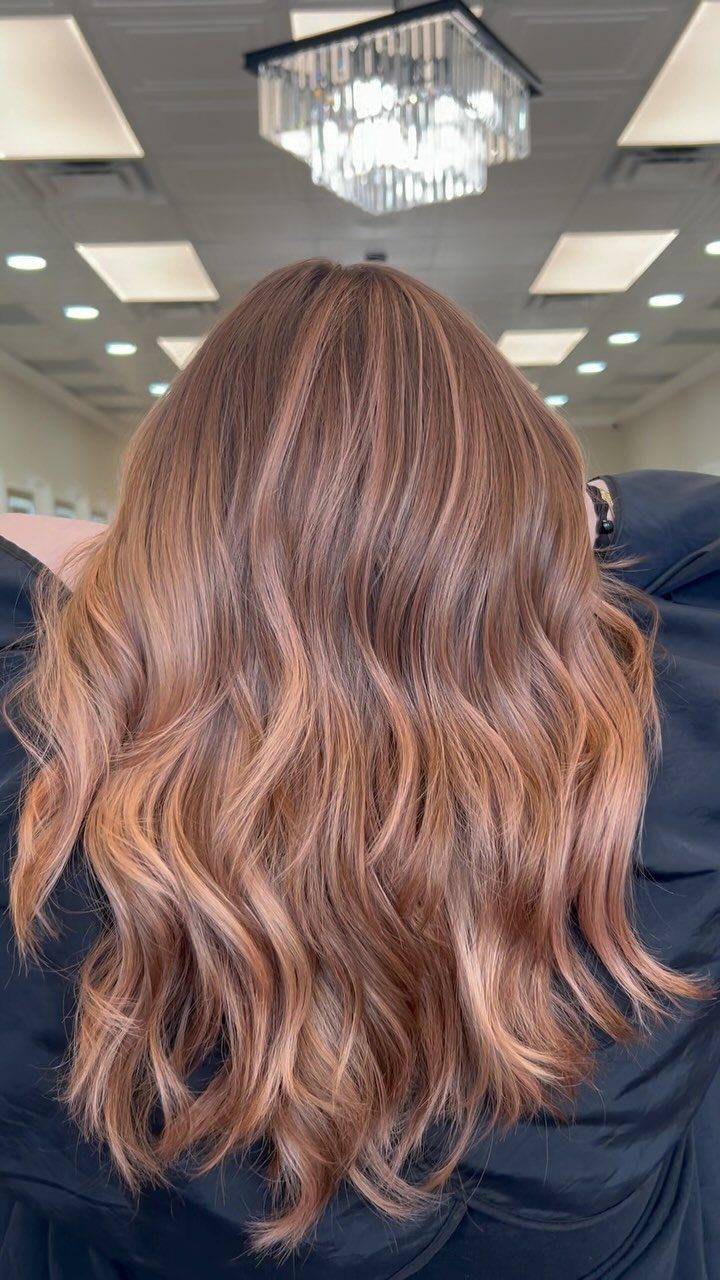 Wavy strawberry blonde hair with softly blended, sun-kissed highlights