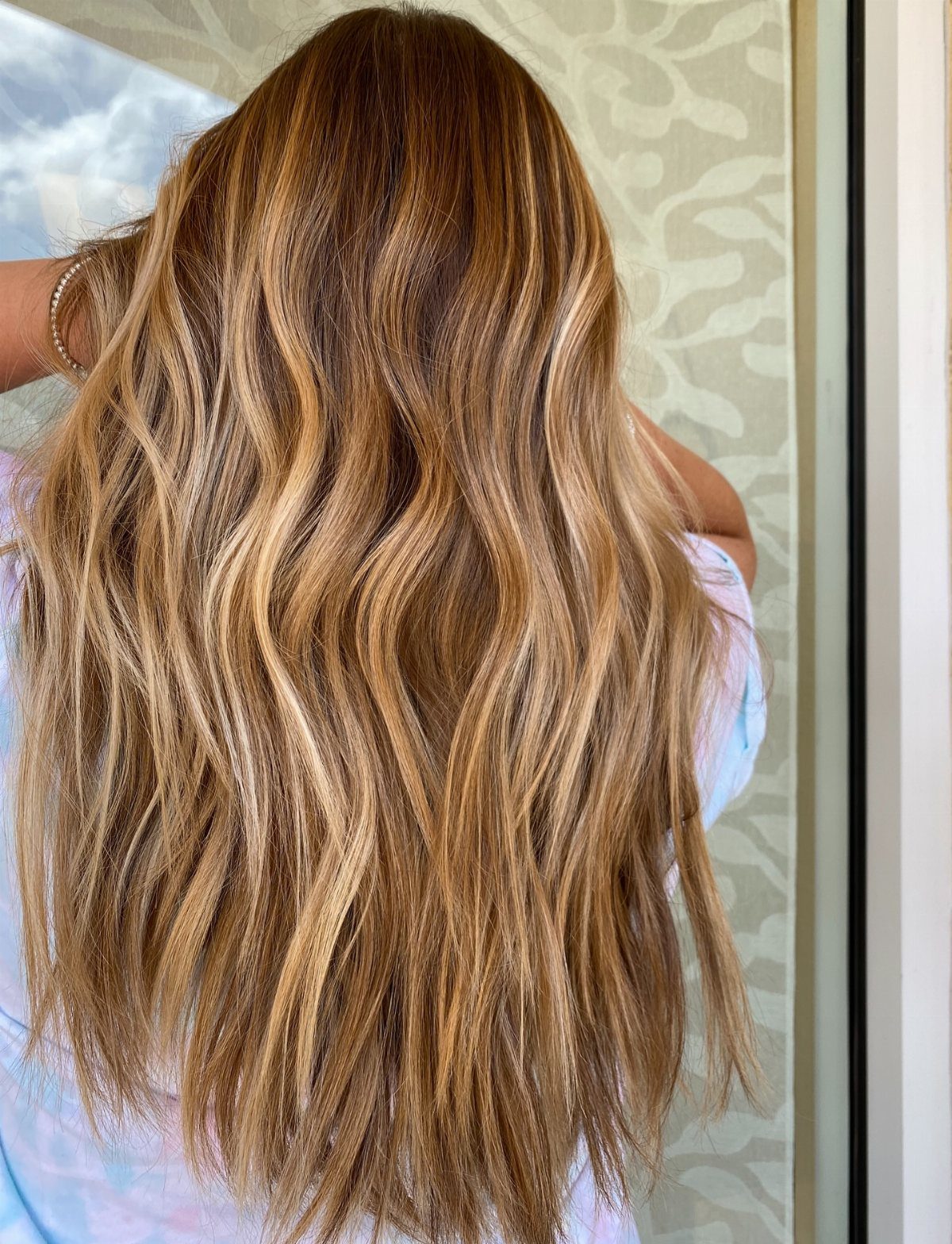 Long brunette hair with golden blonde balayage highlights and soft waves