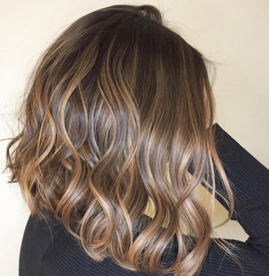 Wavy brown hair with honey-brown highlights and curled ends