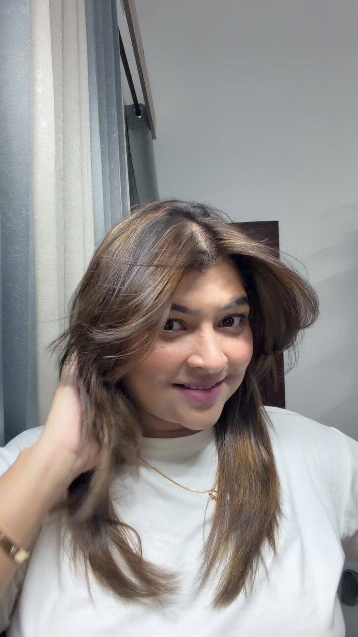 Woman with layered brown hair showing warm caramel highlights around her face