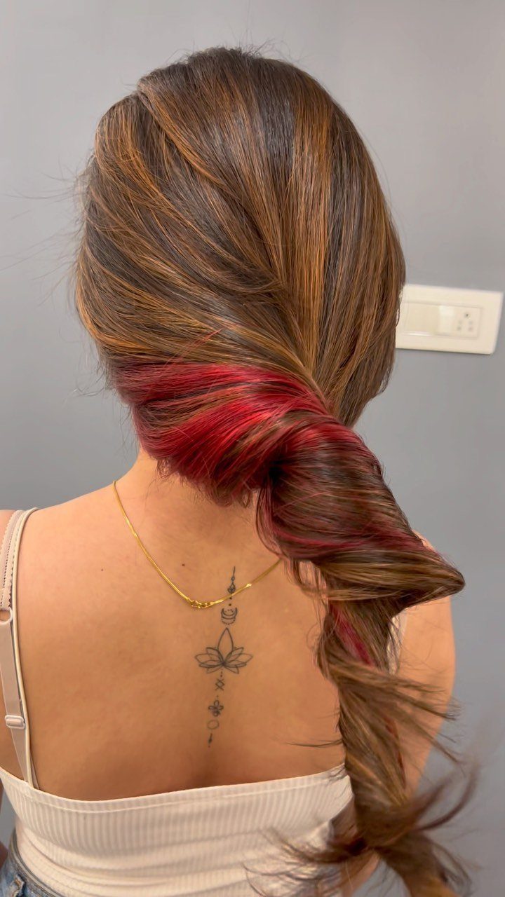 Brown hair with red highlights twisted into a long loose braid
