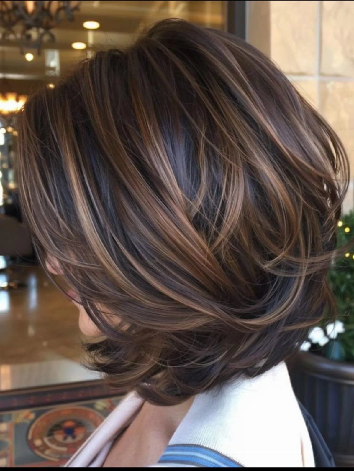 Layered dark-brown bob with sweeping bronze-caramel balayage highlights