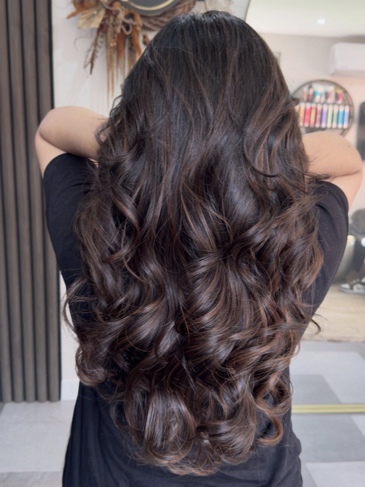 Long dark brown curls show subtle chocolate pecan and caramel tones