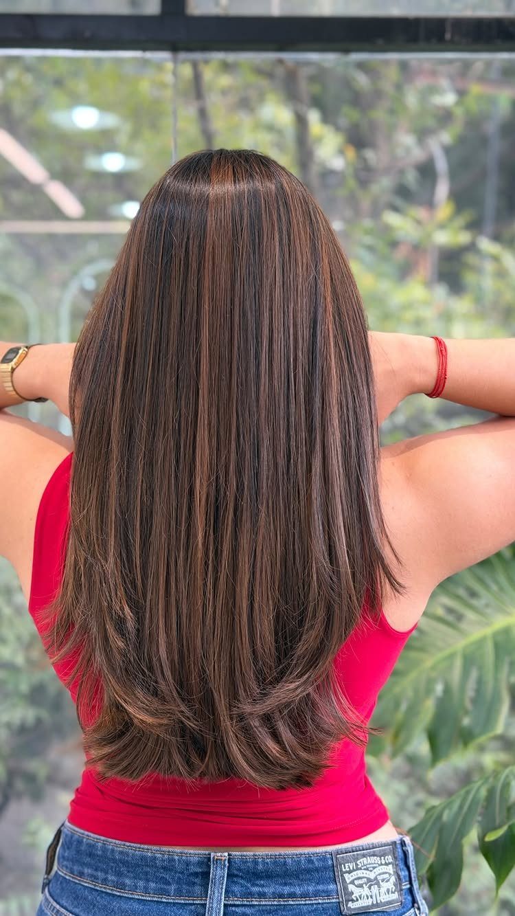 Long dark brown hair with fine warm caramel babylights and softly curled ends