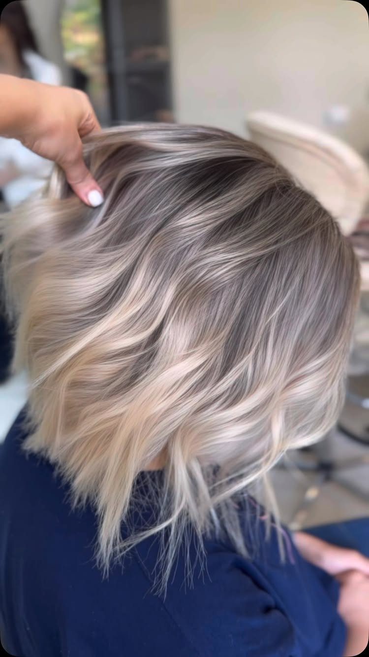 Wavy brunette bob with fine ash-blonde highlights in a salon