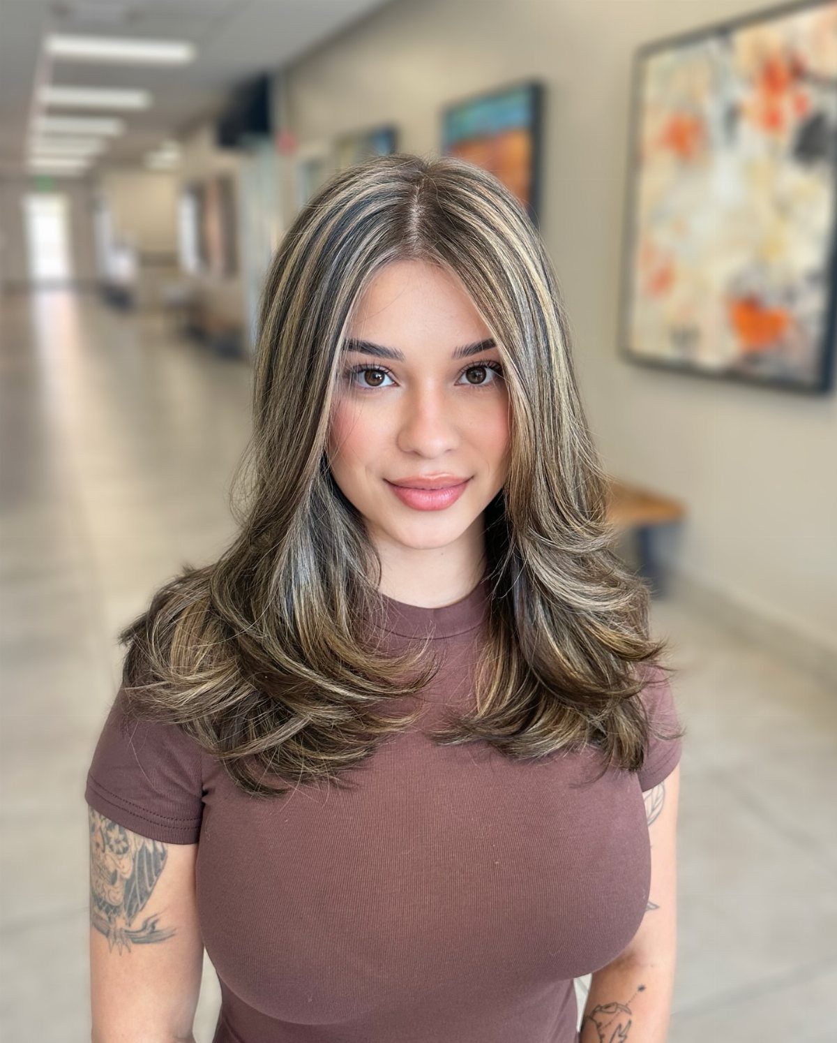 Woman showing brunette hair with chunky blonde ribbons and layered waves