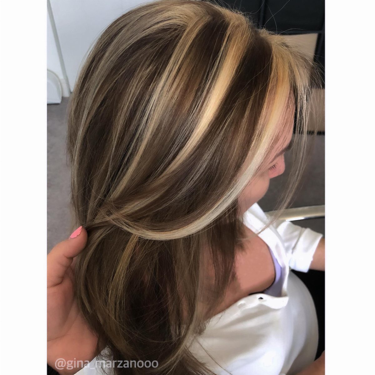Dark brunette hair with chunky creamy-blonde front streaks and blended highlights