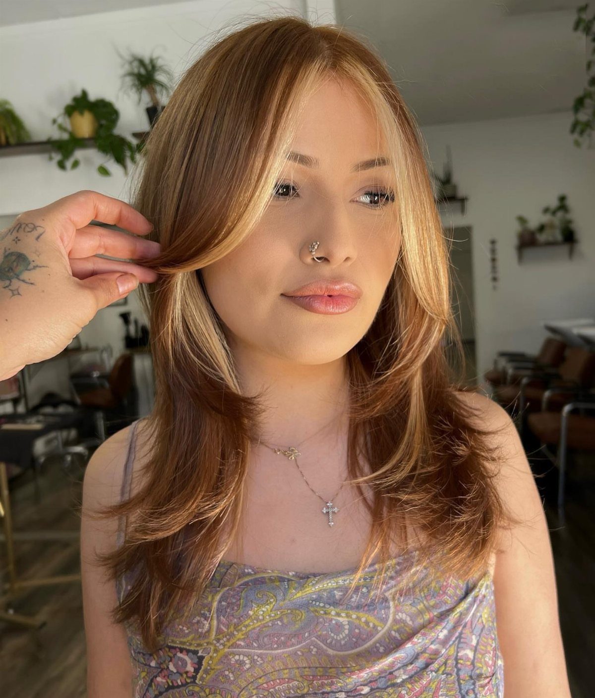 Woman with brunette layered waves and beige-blonde face-framing highlights