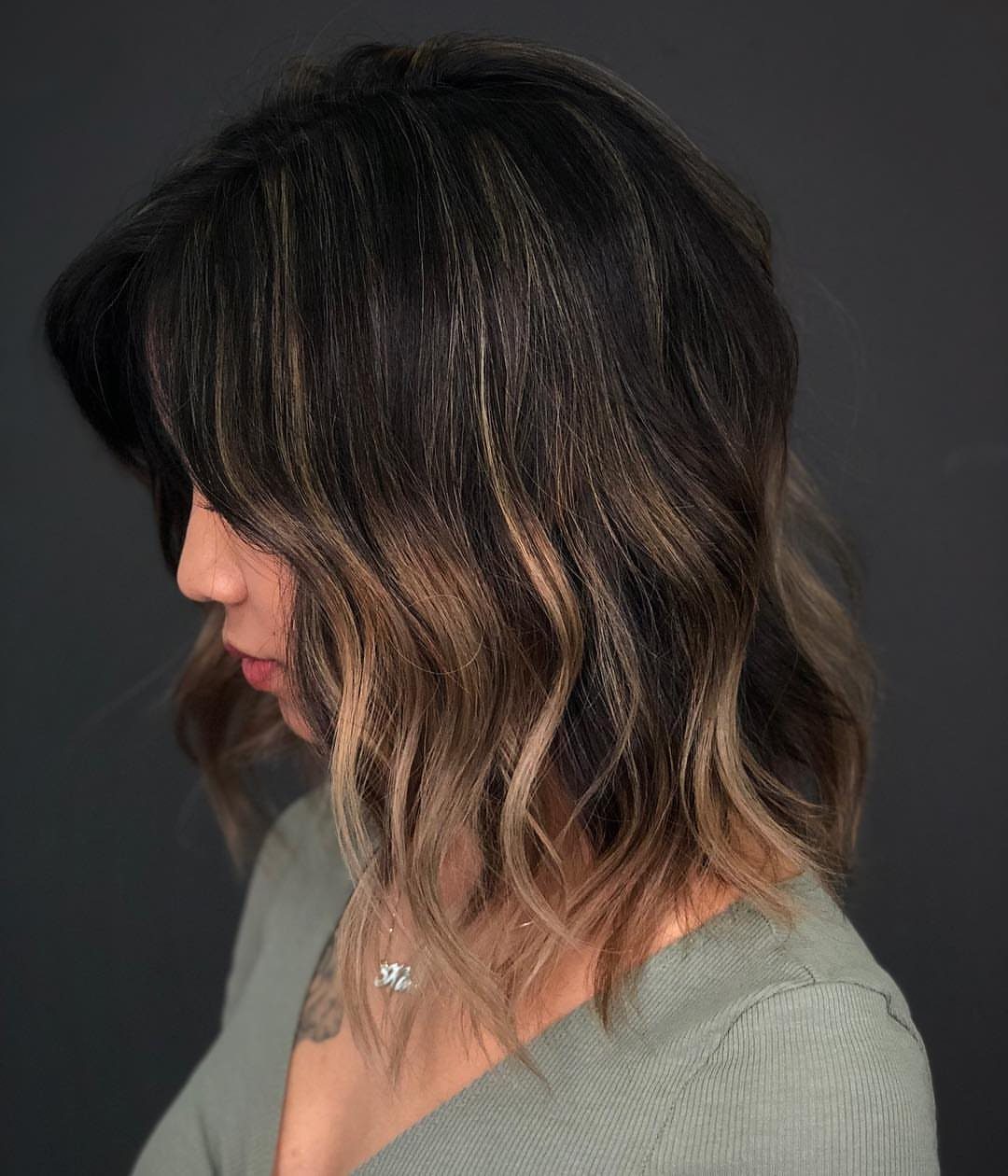 Shoulder-length brunette waves with fine caramel-blonde balayage highlights