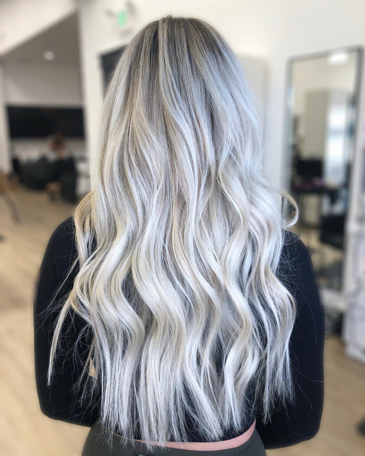 Long wavy hair shows icy-white sections contrasting with dark blonde roots