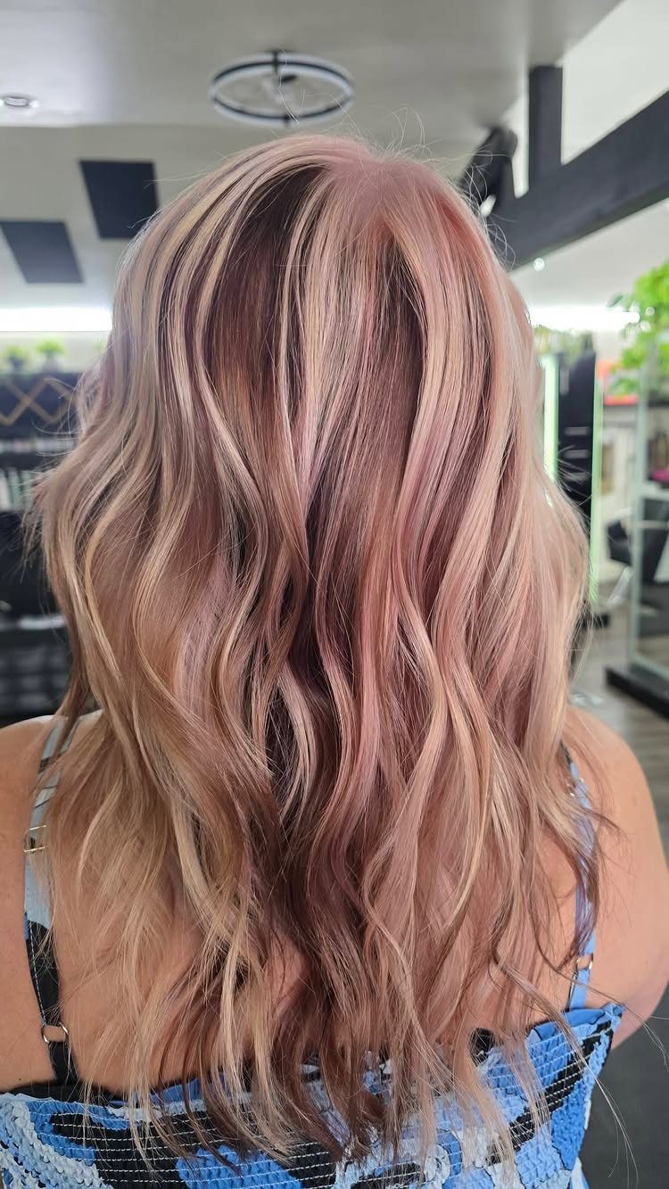 Wavy brown hair with pale pink and blonde ribbons in a salon