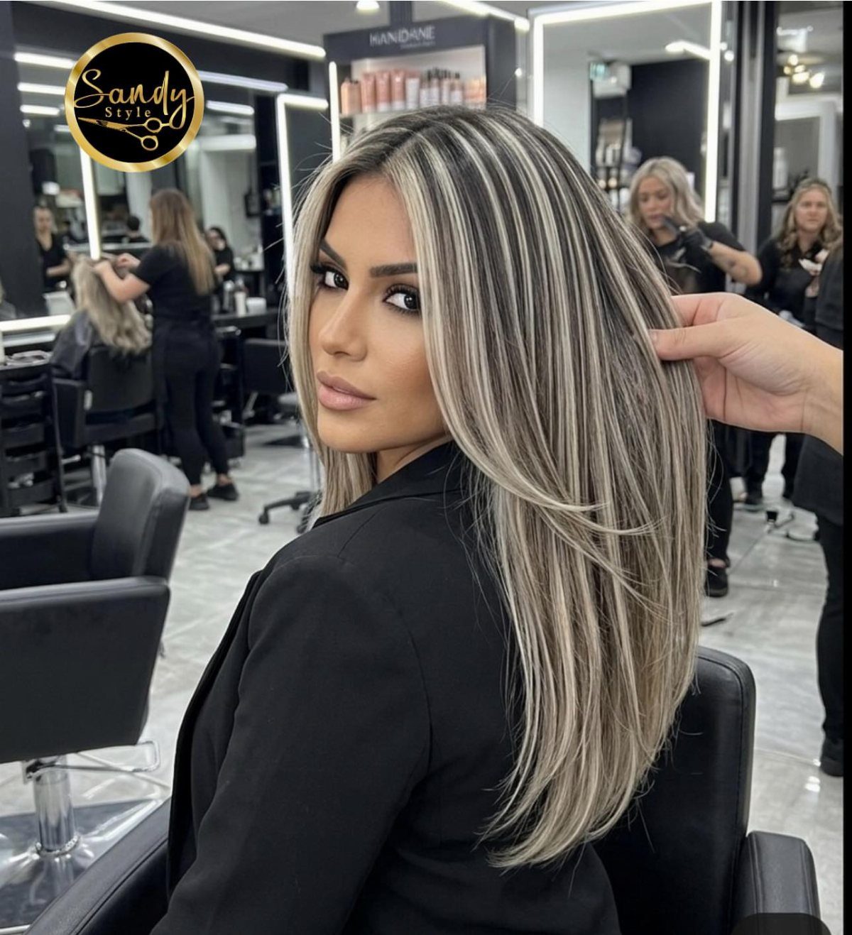 Woman showing long sandy blonde hair with contrasting pale blonde streaks in a salon