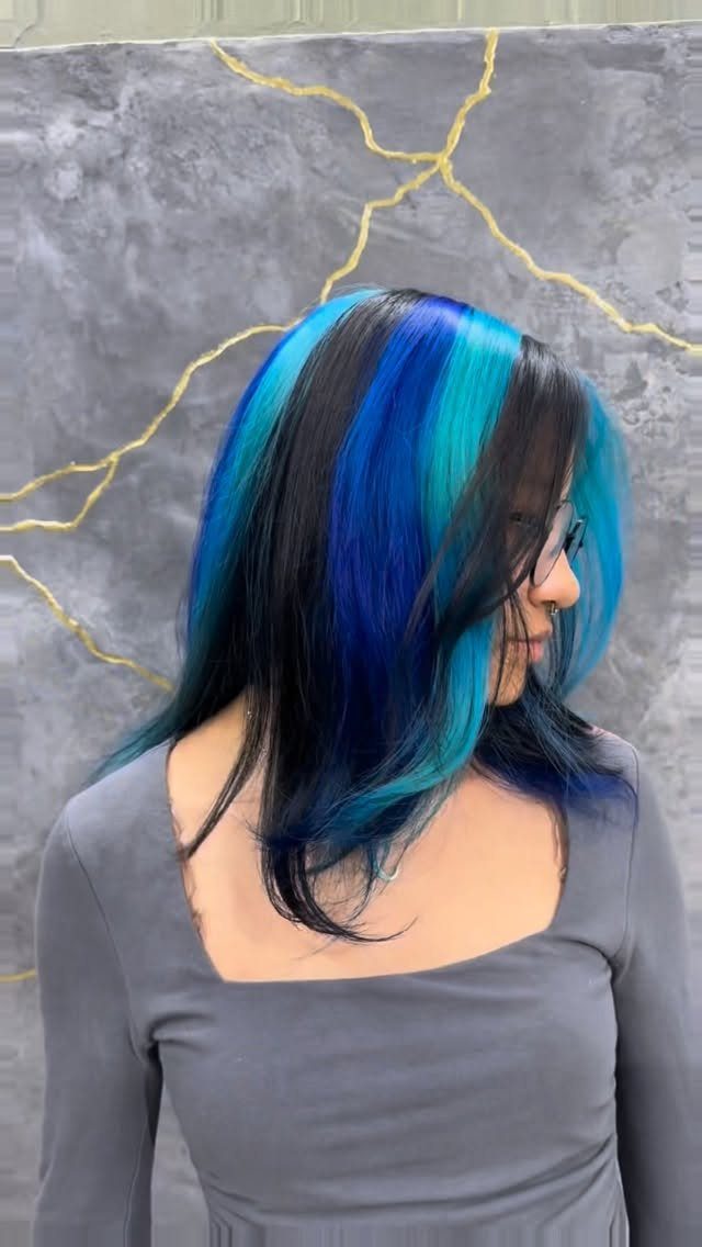 Woman with long black hair and vivid blue and turquoise highlights