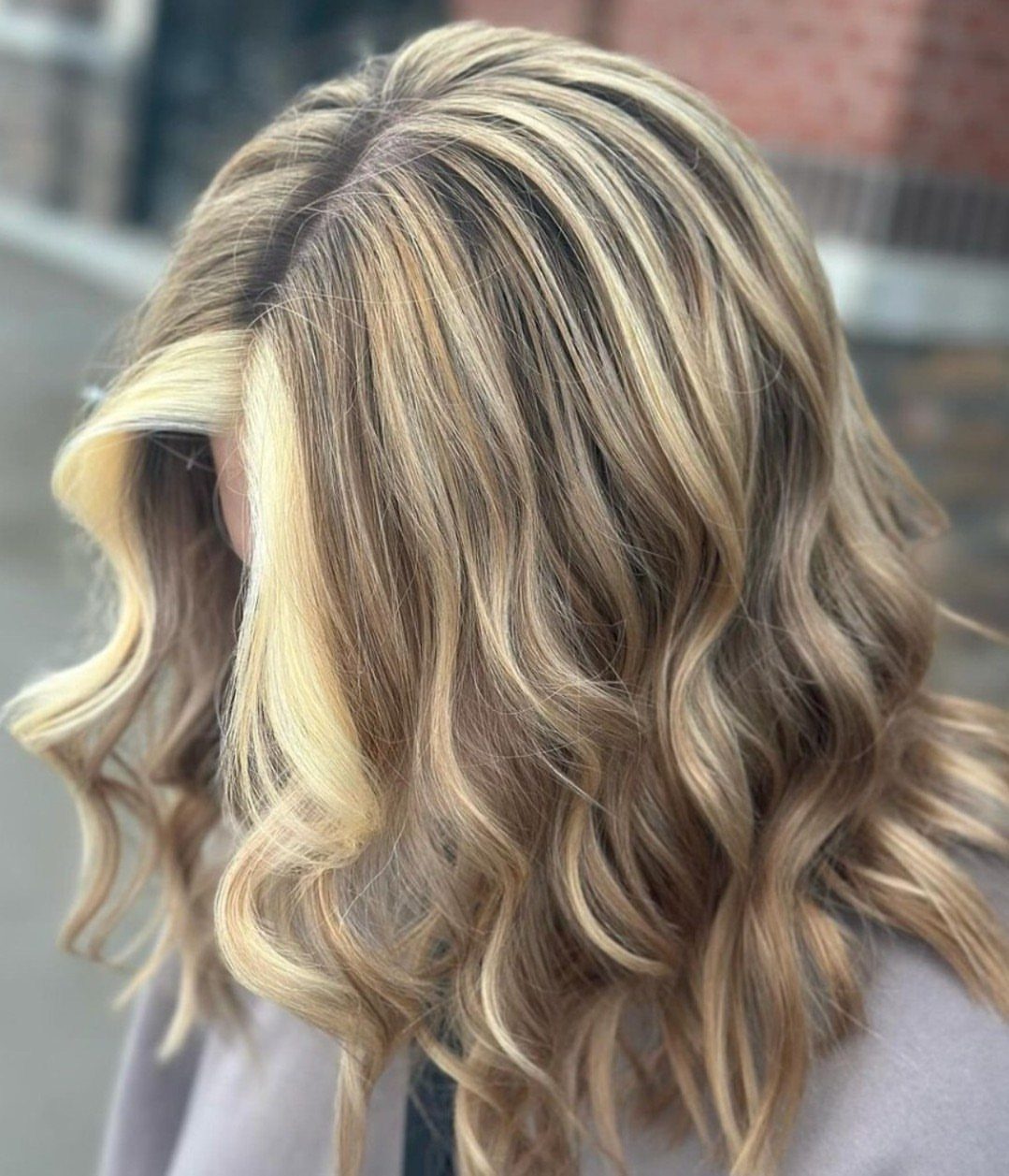 Wavy blonde hair with broad bright ribbons framing the face