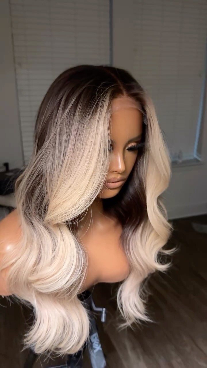 Woman displaying long ash-blonde ombre curls with dark roots