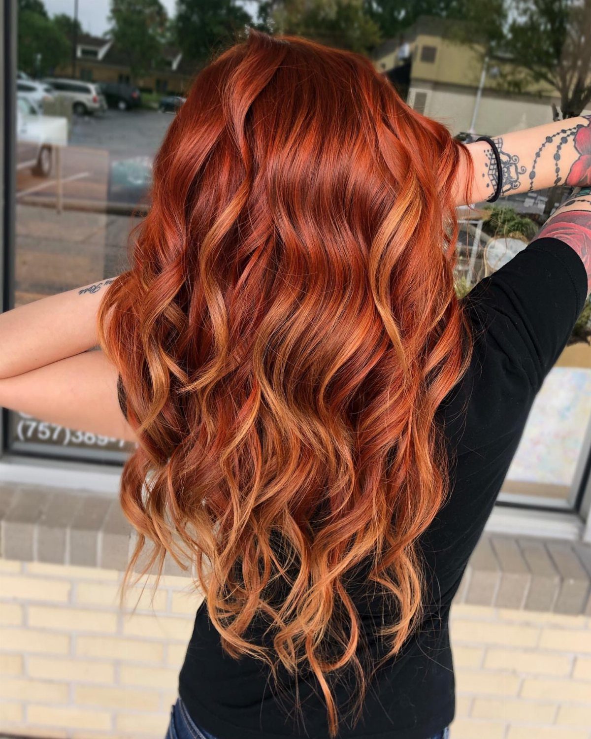 Long wavy copper-red ombre hair with lighter copper strands