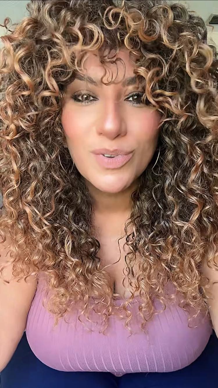 Woman with dark-to-caramel ombre curls framing her face