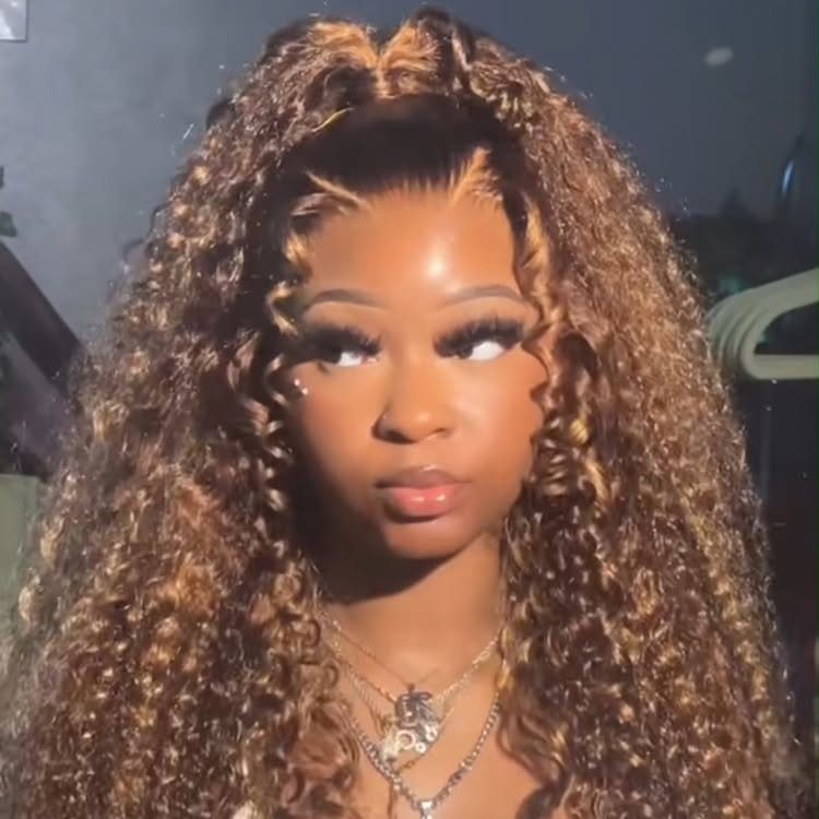 Woman with long brown curls and caramel face-framing highlights