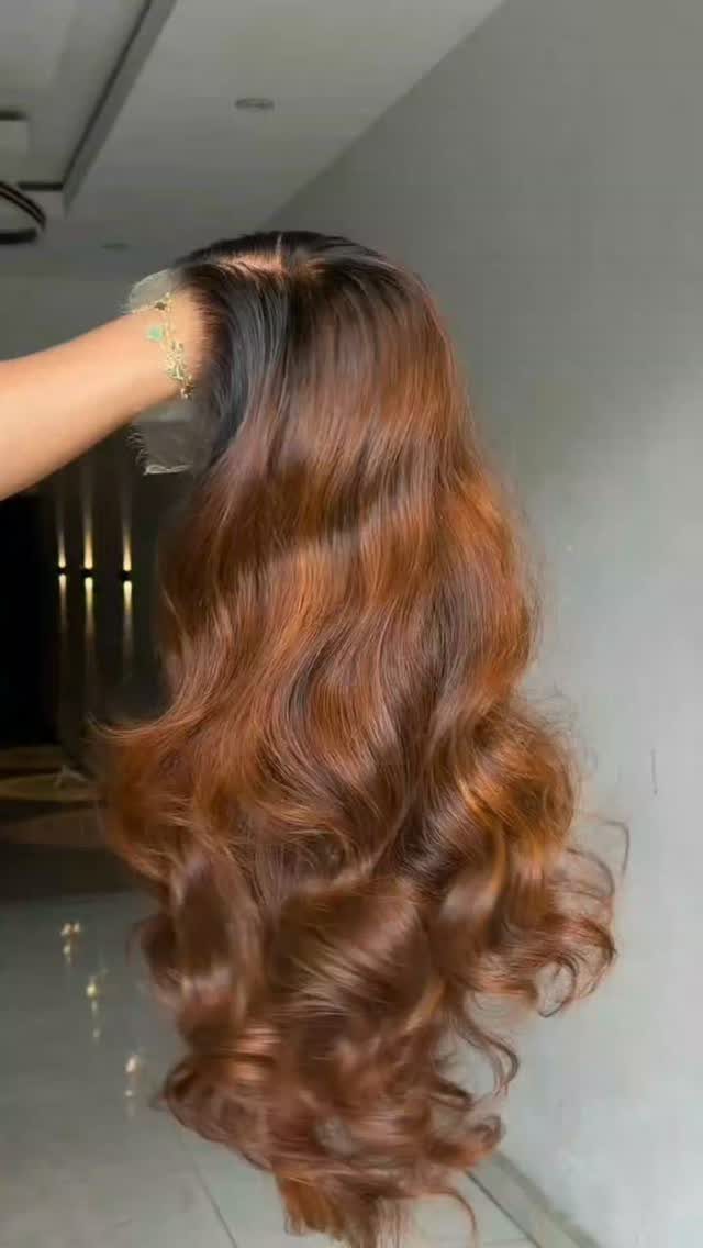 Long curled brown hair transitions to warm reddish copper ends