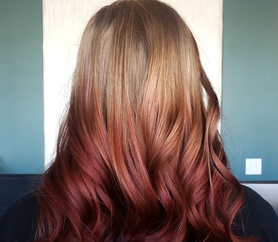 Long wavy hair fading from light brown roots to burgundy ends