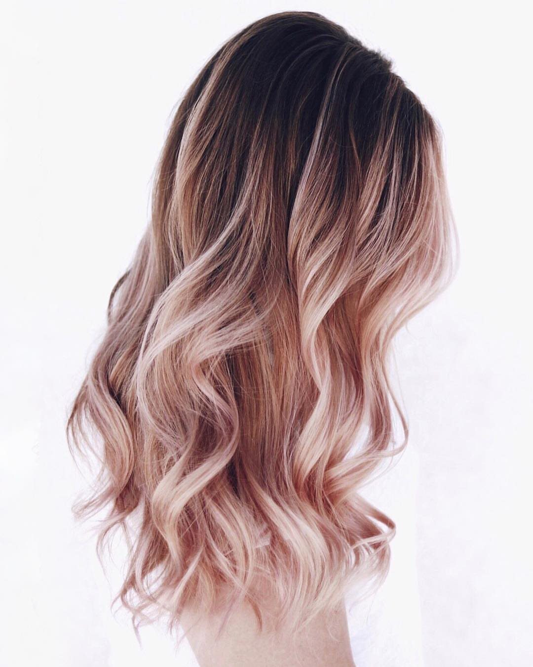 Wavy dark-rooted hair fading into pale rose-gold ends