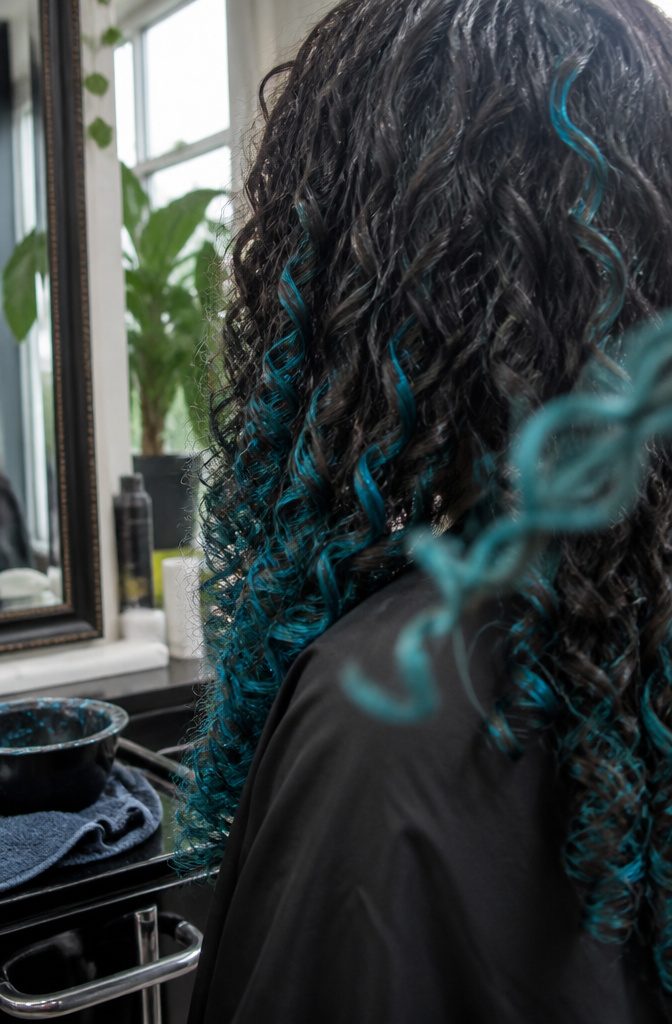 Curly hair with irregular turquoise patches on selected curls