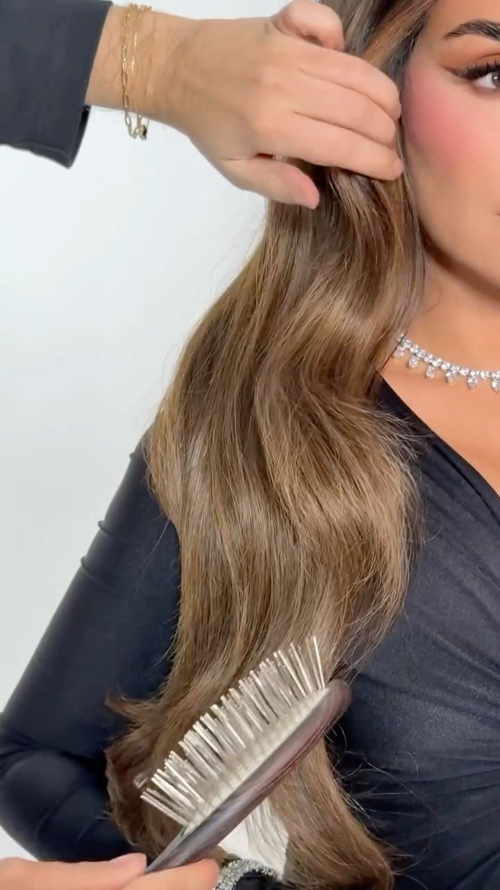 Long dark brown hair with warm caramel balayage highlights being brushed