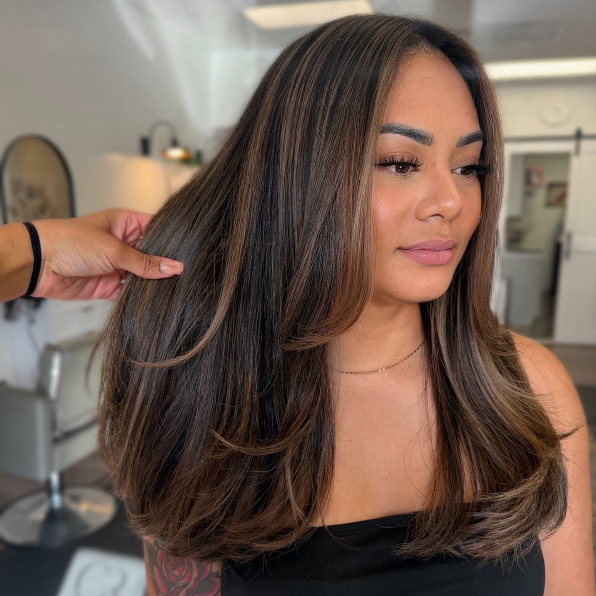 Woman showing multi-toned dark brown balayage in voluminous layered waves
