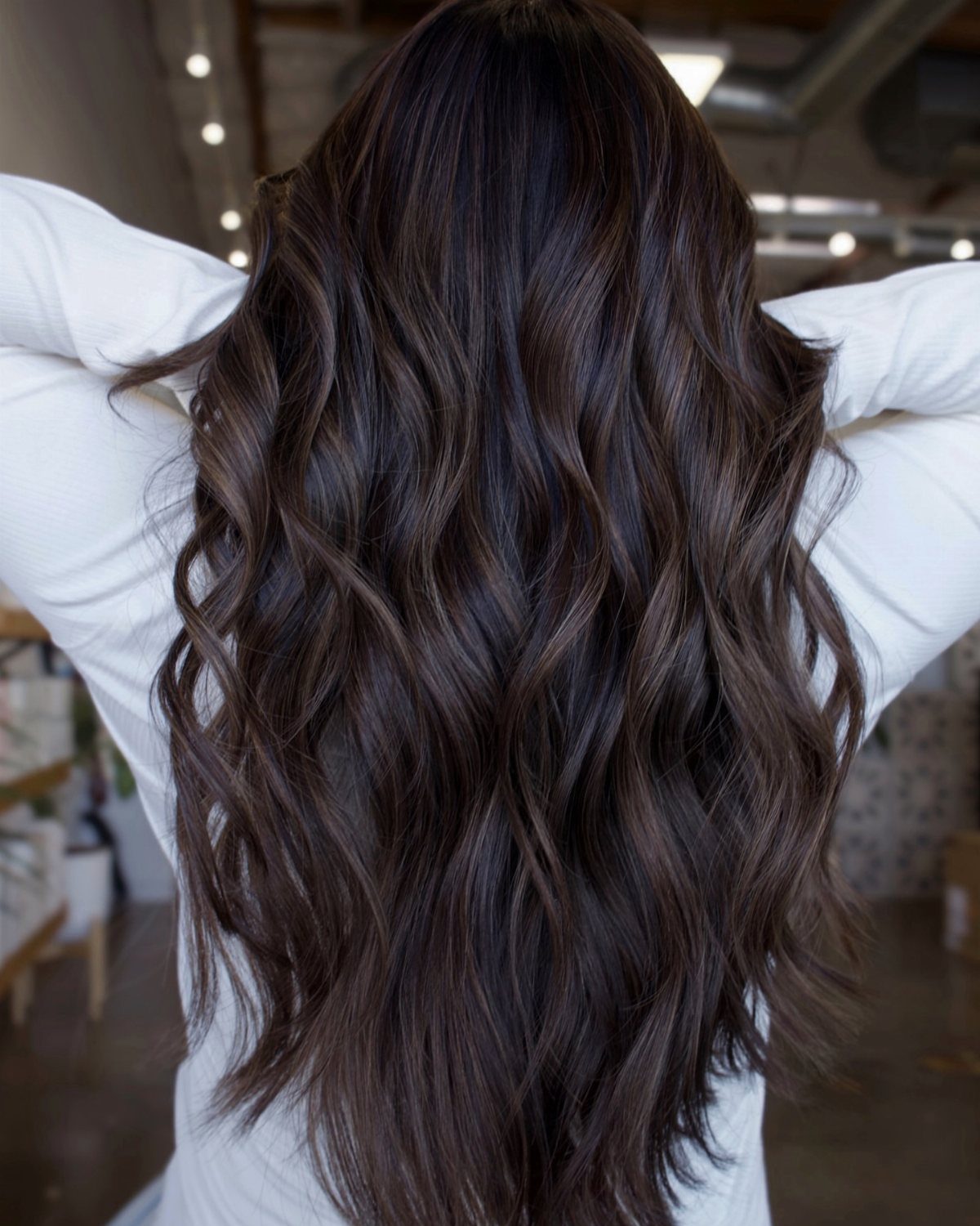 Long wavy dark brown hair with subtle glossy highlights viewed from behind