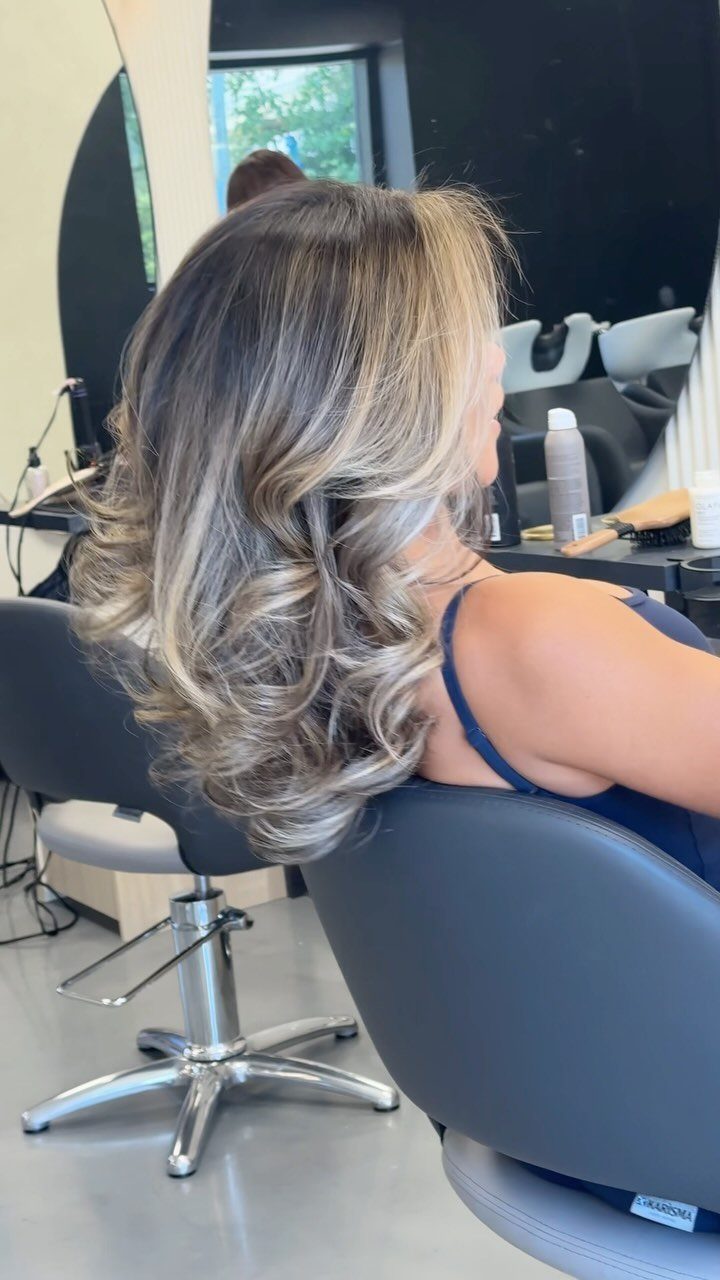 Dark brown hair with bold blonde highlights curled at the ends in a salon