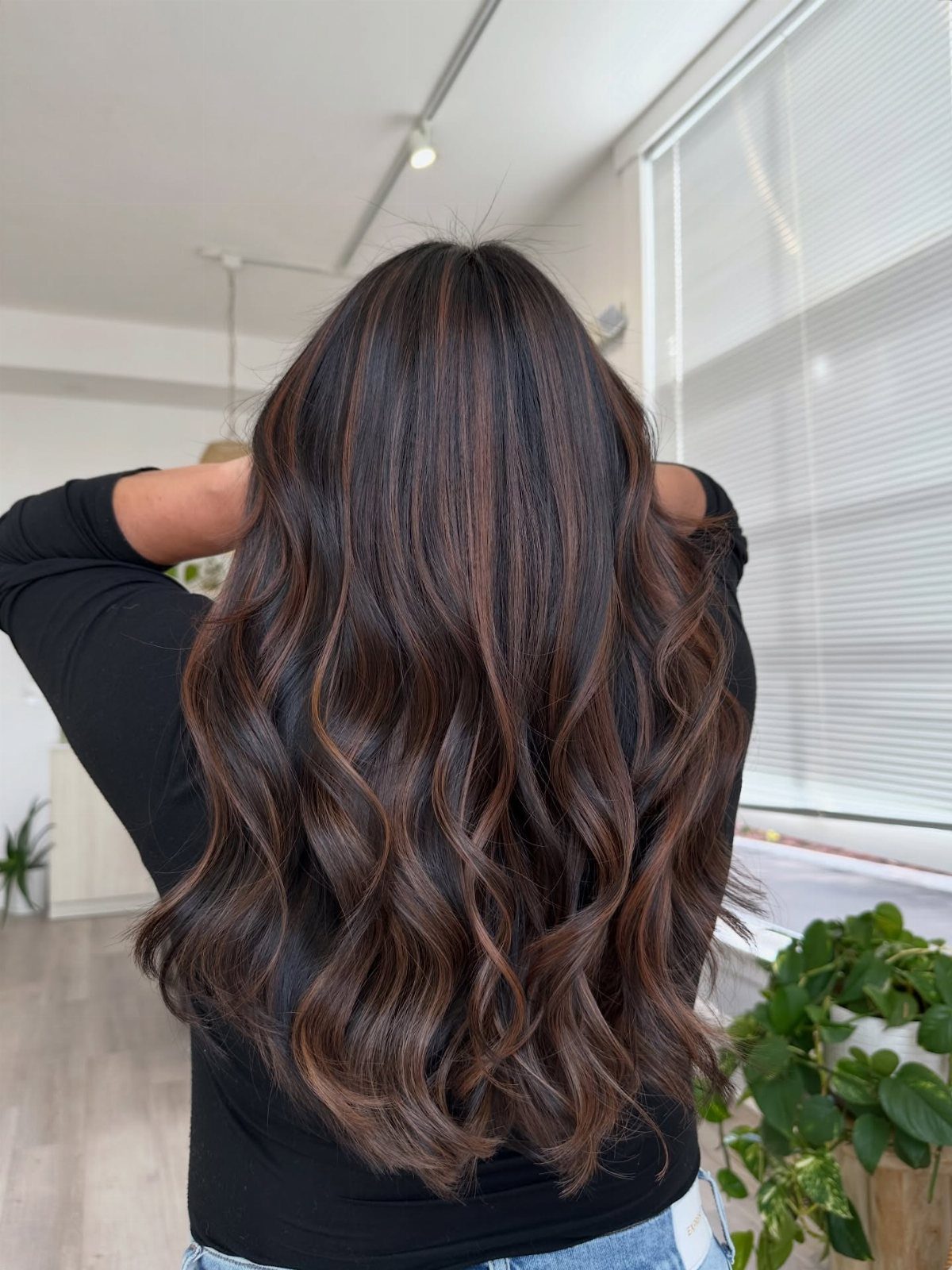 Long dark brown waves with subtle hazelnut-toned balayage highlights