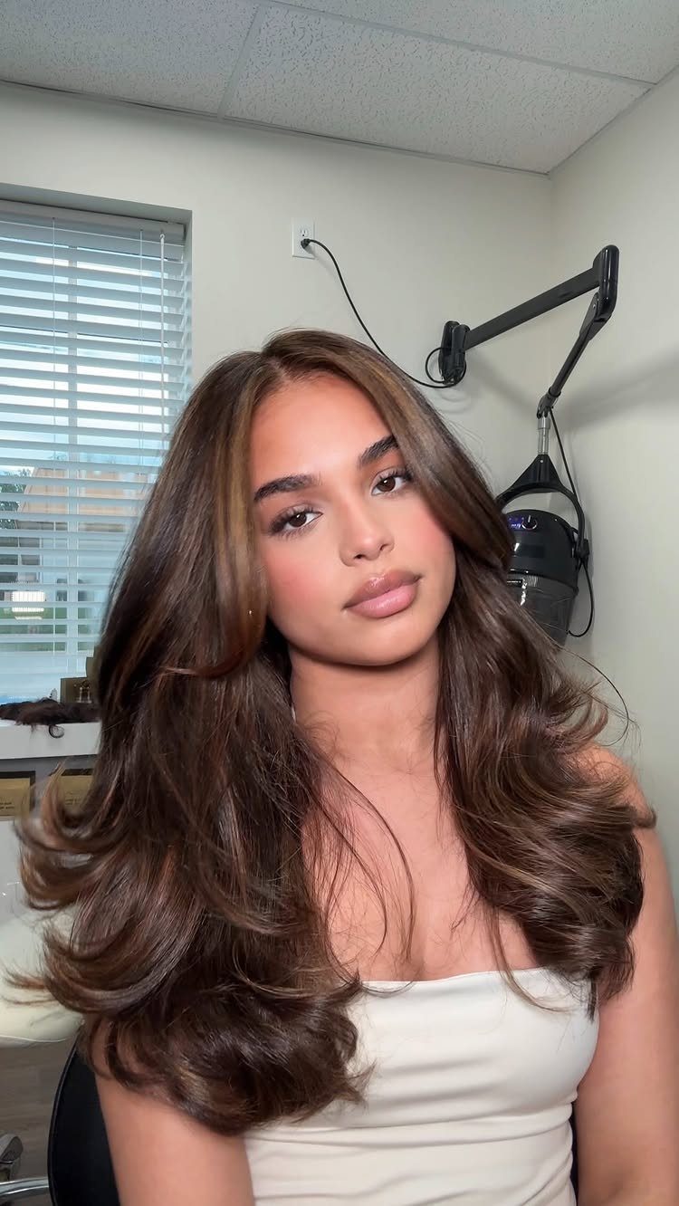 Woman with voluminous dark brown hair and subtle mocha-toned highlights