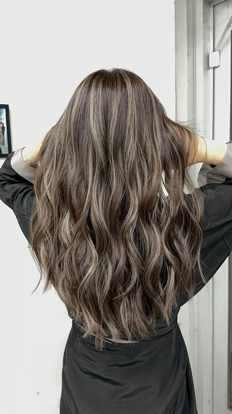 Long wavy dark brown hair with cool ash-blonde balayage highlights