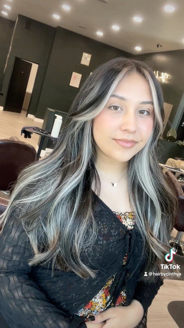 Woman with long dark brown hair and cool blonde and silver highlights