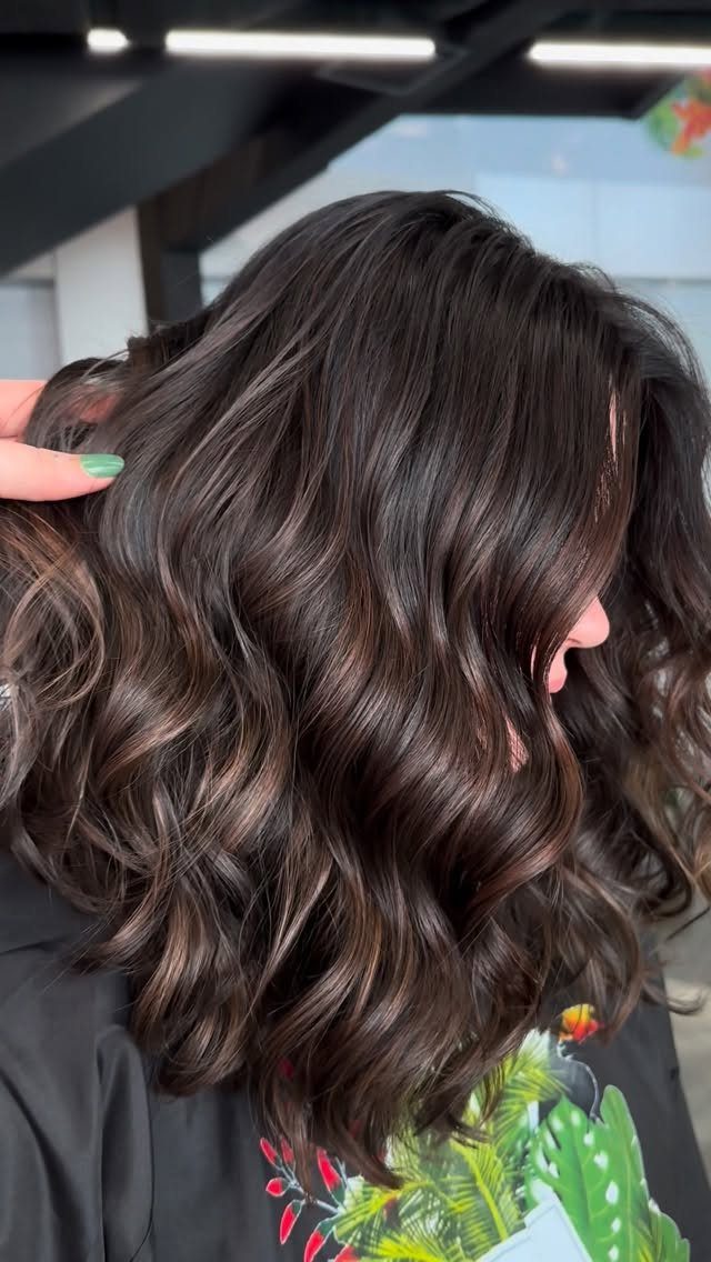Wavy dark brunette hair with subtle chocolate brown highlights