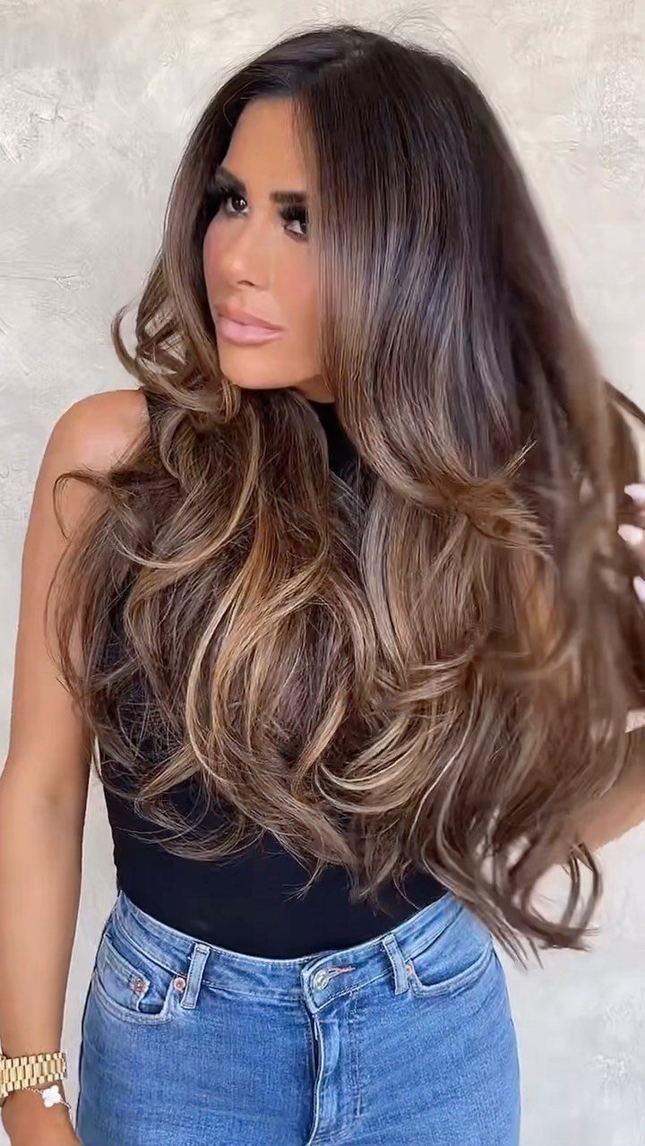 Woman with long dark brunette curls and warm brown highlights