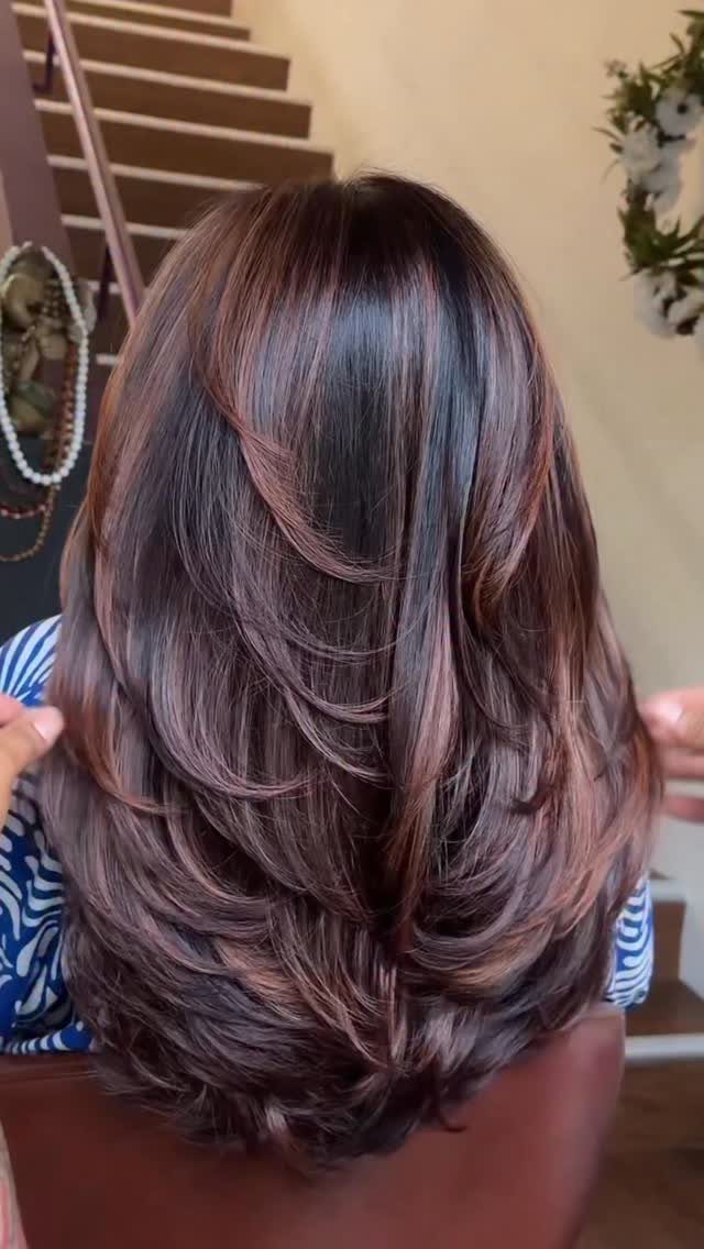 Layered dark brunette hair with contrasting reddish-brown highlight strands