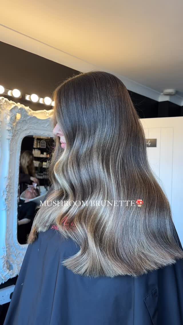 Dark brunette hair with muted gray-brown highlights and softly curled ends