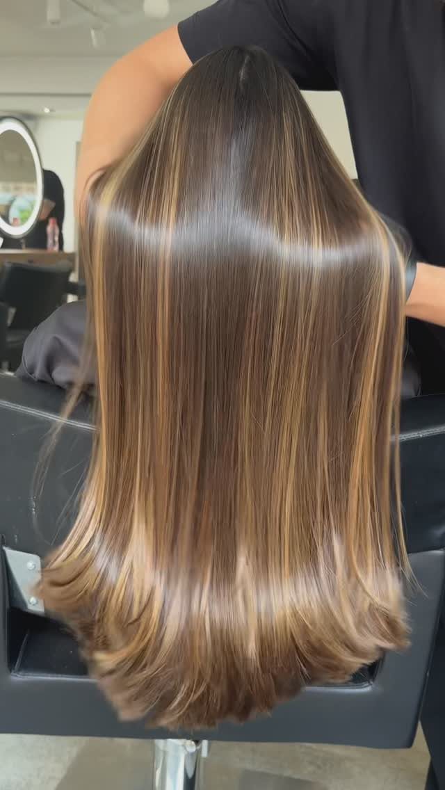 Long brunette hair with fine caramel highlights and softly curled ends