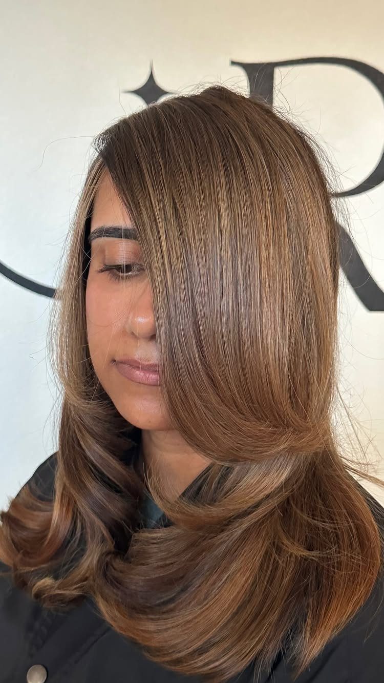Brunette hair with blended bronde highlights and curled ends