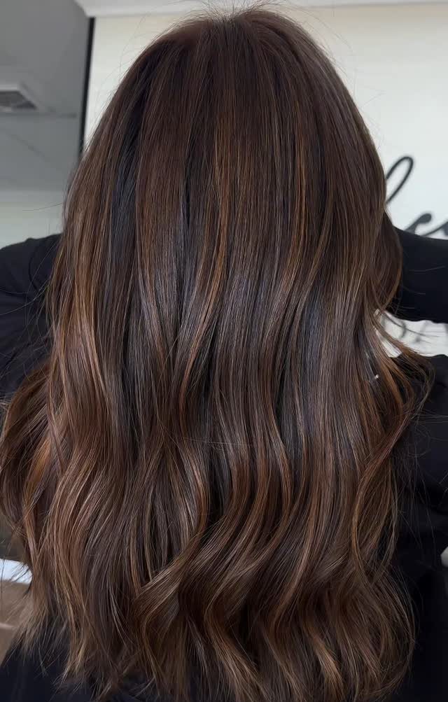 Long wavy brunette hair with soft caramel balayage highlights