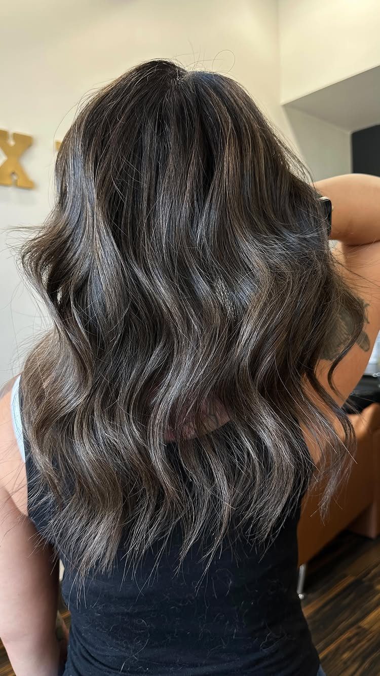 Wavy dark brown hair with lighter highlights and darker lowlights