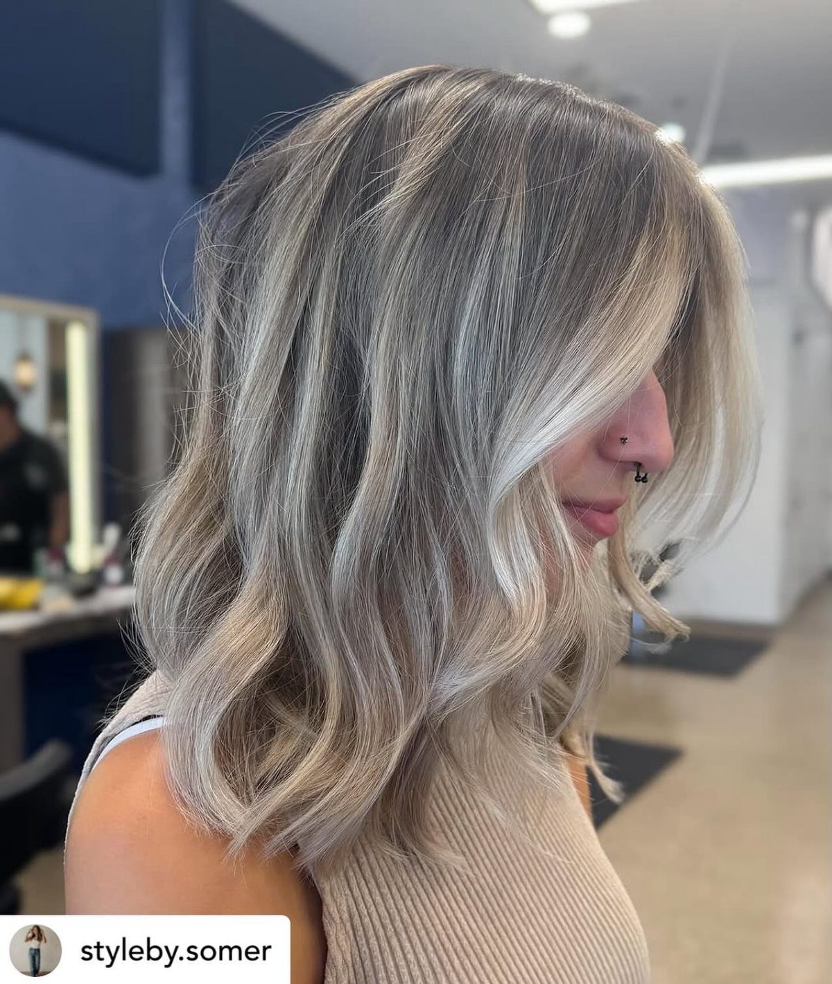 Wavy ash-blonde hair with smoky dark roots and pale face-framing strands