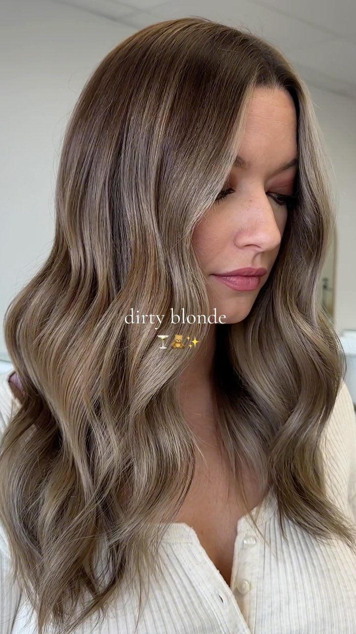 Woman showing long, dimensional dirty blonde hair with darker lowlights and soft waves