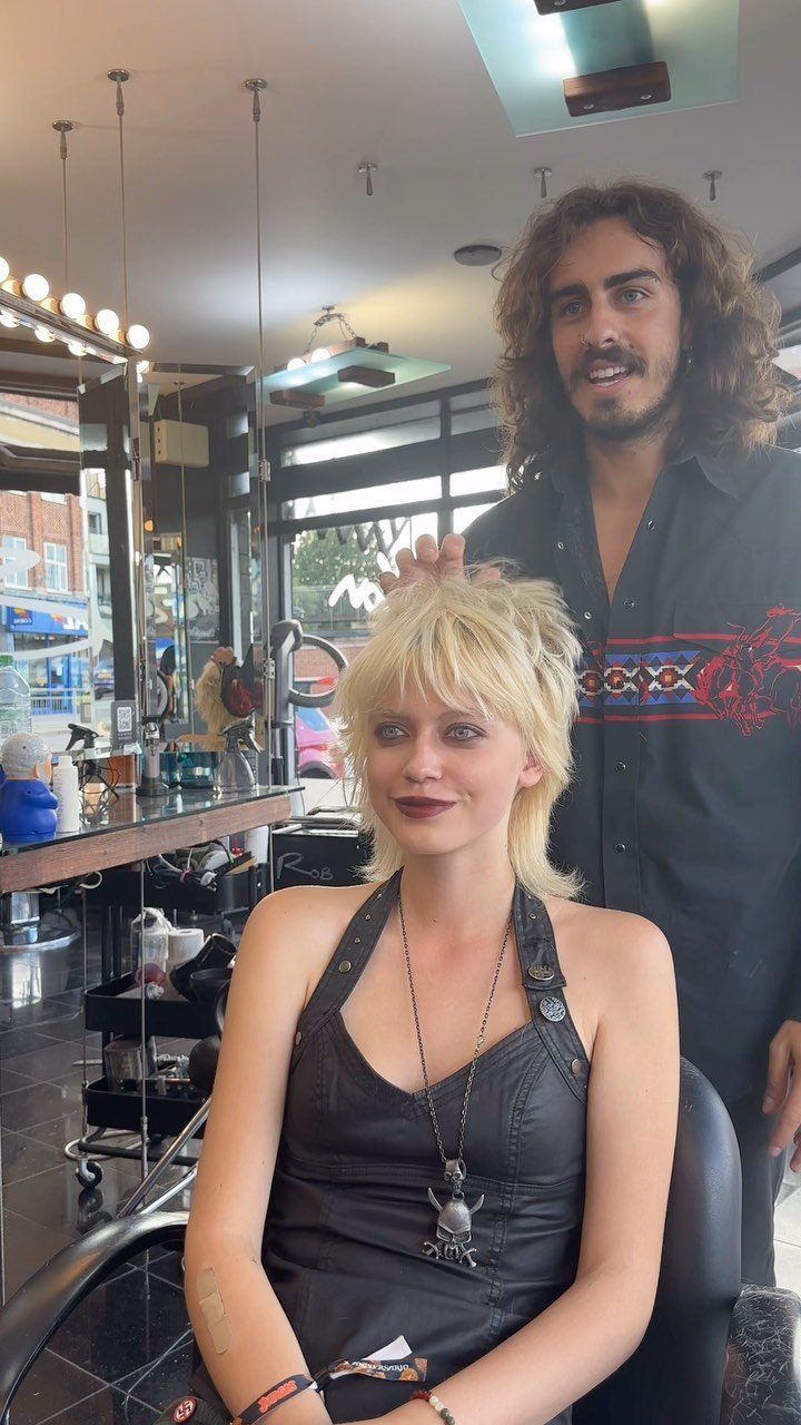 Woman with a short, tousled blonde shag and bangs seated in a salon